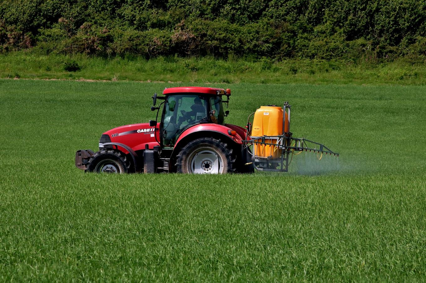 Photo d'illustration d'un tracteur sprayant un produit sur un champs