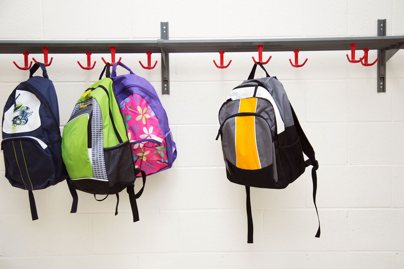 Photo d'illustration de sacs d'école suspendus sur des crochets